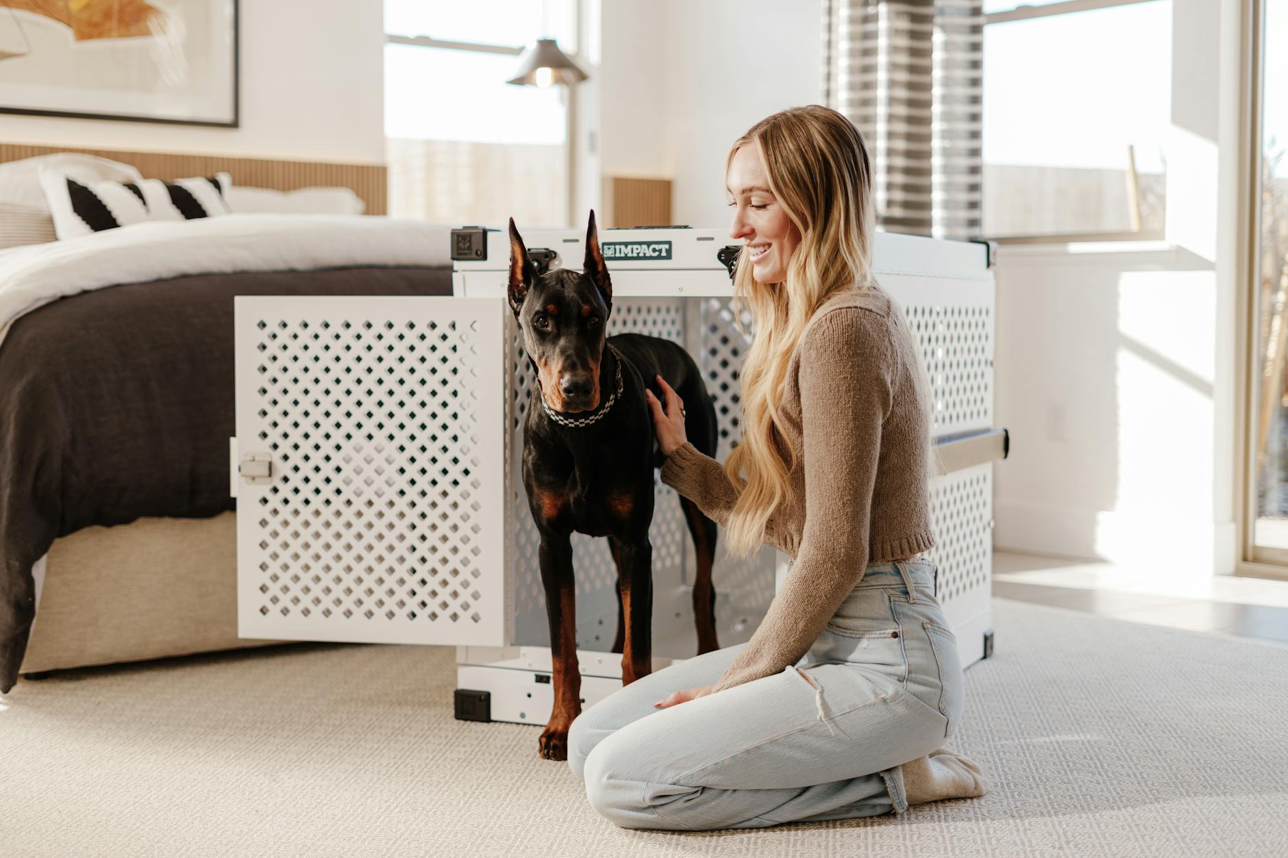 young woman with doberman in stylish bedroom